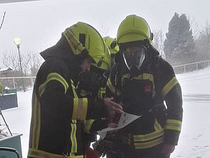 Vier Feuerwehrmänner besprechen einen Plan