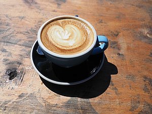 Tasse mit Kaffee auf Holzoberfläche