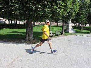 Mann mit läuft mit Langstock im Park