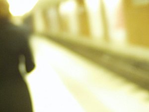 Verschwommenes Foto von einem Bahnsteig, eine Person steht mit dem Rücken zur Kamera