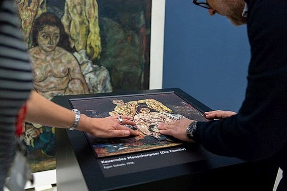 Ein Mann und eine Frau Tasten das Tastrelief des Gemäldes von Egon Schiele ab.