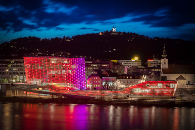 Spezialführung im Ars Electronica Center Linz. Foto: Ars Electronica Center. Ars Electronica von außen abends rosa und rot leuchtend