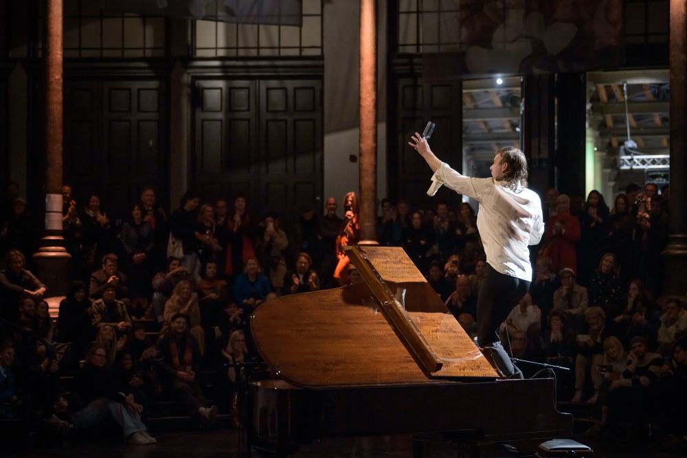 Ein Mann mit auf einer Bühne mit einem Mikrofon in der Hand