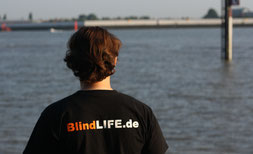 Erdin Ciplak von hinten, mit Logo BlindLife.de auf der Rückseite seines T-Shirts, Copyright: BlindLife.