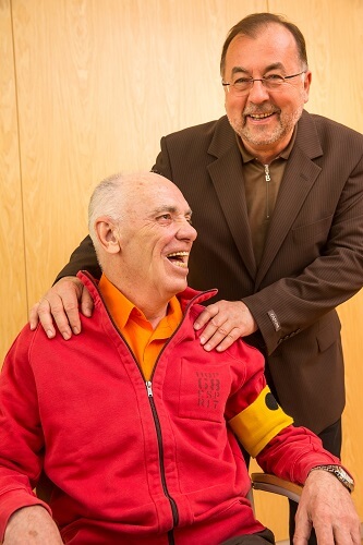 Ein Mitglied und ein Ehrenamtlicher lachen zusammen, Copyright: Franz Pfluegl.