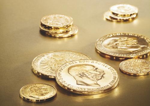 Goldmünzen bieten Sicherheit. Copyright: Münze Österreich AG Verschiedene Goldmünzen auf goldenem Untergrund.