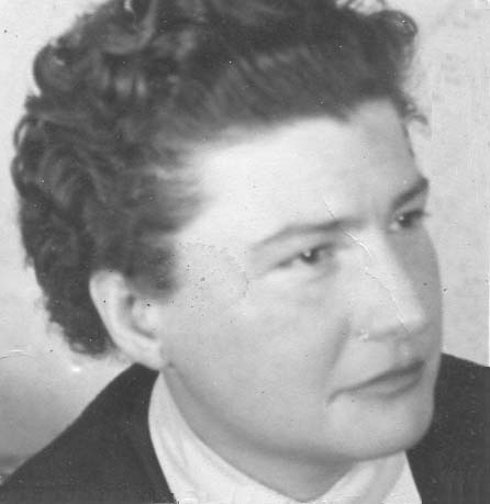 Schwarz-Weiß Bild einer Dame mittleren Alters mit Dauerwelle die ernst außerhalb des Bildes blickt