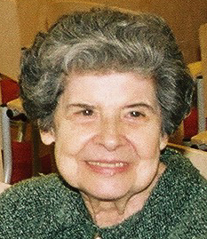 Eine ältere Dame mit grauer Dauerwelle lächelt freundlich