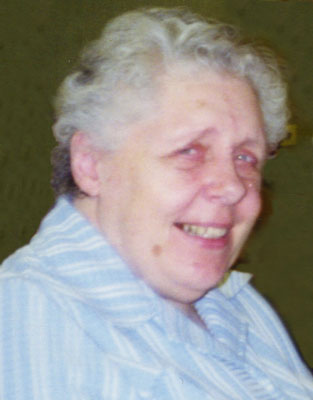 Portrait einer älteren Dame mit Dauerwelle die freundlich lächelnd seitlich in die Kamera blickt