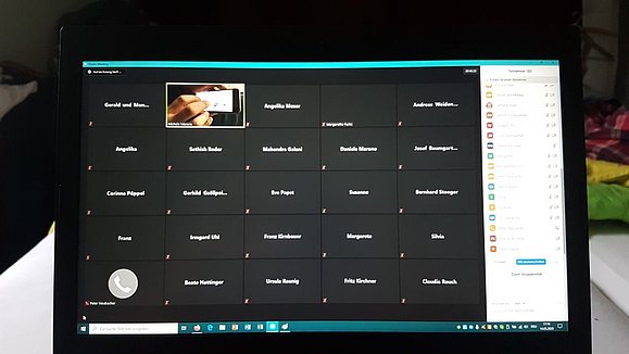 Ein Foto von einem Computerbildschirm auf dem ein Zoom-Meeting läuft. Mehrere Kästchen mit Namen sind zu sehen.