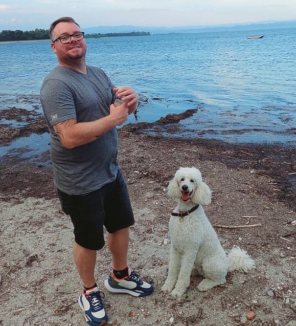 Mann mit weißem Hund vor Meer