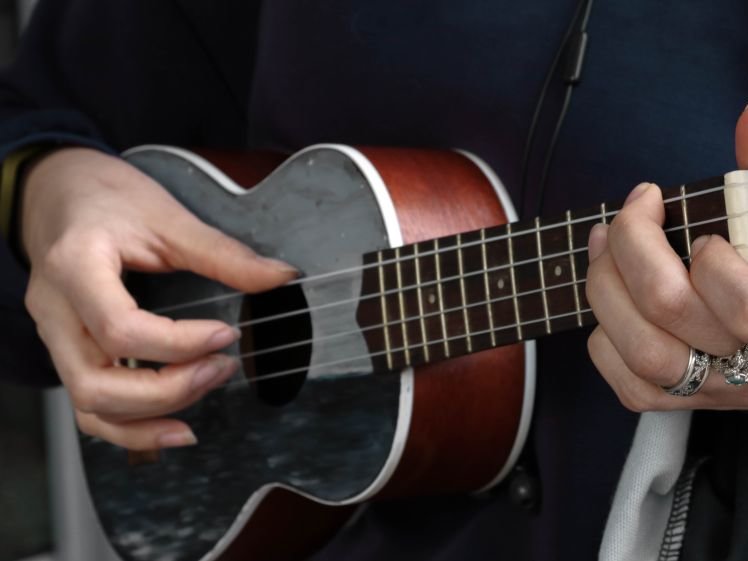 Hände spielen die Ukulele