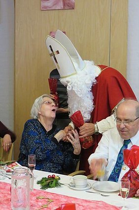 Nikolaus schüttelt einer Frau, die sich freut, die Hand