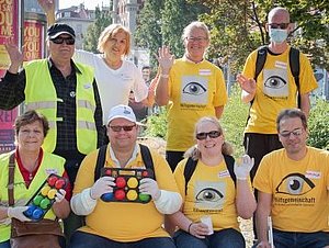 Mitglieder der Hilfsgemeinschaft bei einem Boggia-Ausflug: Neun Menschen winken fröhlich vom Gruppenfoto