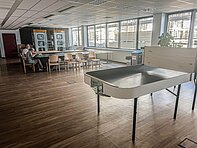 Vienna_AT_Incubation_Centre Großer Raum, modern eingerichtet mit Tischen und 2 Telefonzellen