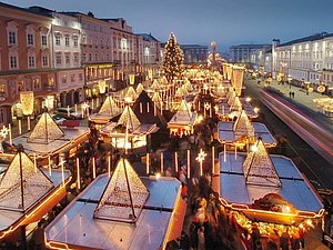 Leuchtende Christkindlmarkthütten von oben in Dämmerung