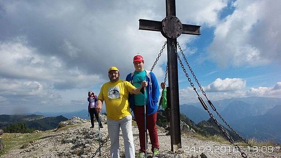 Vater und Sohn stehen neben dem Gipfelkreuz