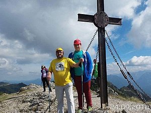 Vater und Sohn stehen neben dem Gipfelkreuz