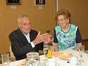 Ein älterer Herr und eine ältere Dame sitzen bei einem Glas Sekt