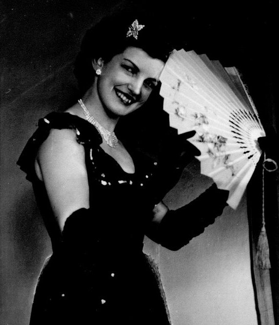 Junge Frau in schwarz-weiß mit elegantem Abendkleid und Fächer