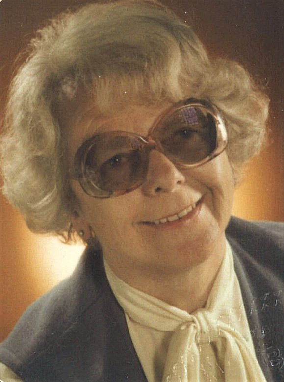 Ältere Frau mit Föhnwelle und großen abgedunkelten runden Brillen lächelt