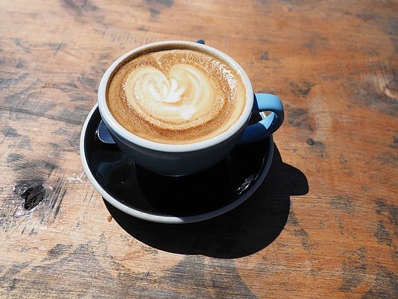 Tasse mit Kaffee auf Holzoberfläche