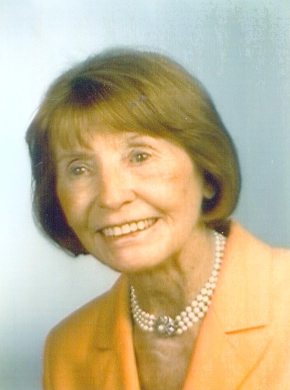 Portrait einer älteren Dame mit mehrreihiger Perlenkette, freundlich lächelnd, sie blickt an der Kamera vorbei