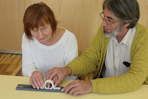 Wolfgang Zagler zeigt einer blinden Testperson die Versuchsmuster.