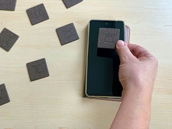 Hand hält Memorykarte auf ein Smartphone