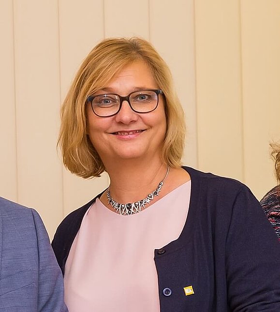 Frau mit blauer Weste und rosa Shirt