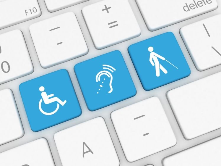 PC Tastatur Nahaufnahme: 3 Tasten in blau, davon 1 mit Rollstuhl Icon, 1 mit Ohr Zeichen für Gehörlosigkeit, 1 mit Person mit Langstock