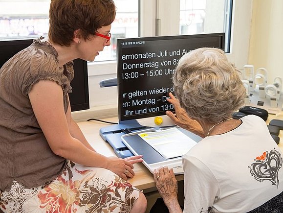 Unsere Beraterin testet Bildschirmlesegeräte mit einem sehbehinderten Mitglied.