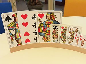 Auf einem Spielekartenhalter sind 3 große, 3 mittlere und 4 kleine Karten eingesteckt.