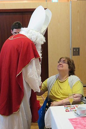 Nikolaus schüttelt einer Frau die Hand