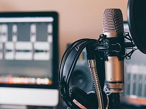 Nahaufnahme Mikrofon mit Kopfhörern dranhängend