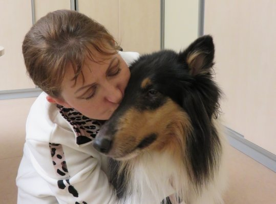 Eine Frau küsst Blindenführhund Lilli auf die Schnauze