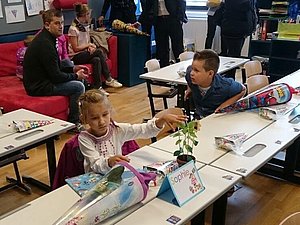 Kinder sind mit Schultüten in einer Klasse und haben ihren ersten Schultag