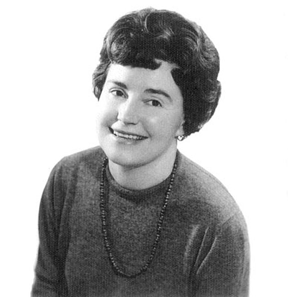 Schwarz-Weiß-Foto einer jungen Dame die freundlich in die Kamera lächelt.