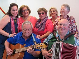 Eine Gruppe, bei der zwei Personen eine Gitarre und ein Akkordeon verwenden