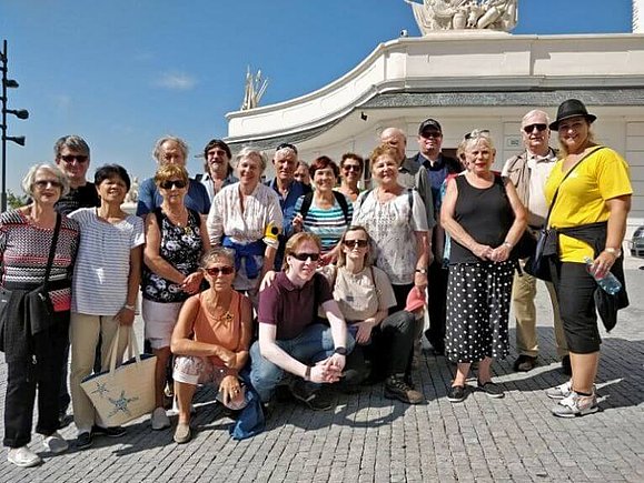20 Personen posieren zusammen bei sonnigem Wetter für ein Gruppenfoto