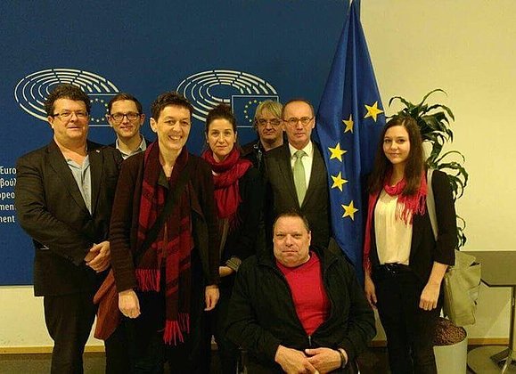 Klaus Höckner possiert mit einer Gruppe von Menschen beim European Disability Forum in Brüssel.