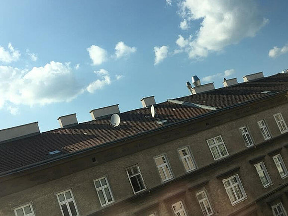 Haus mit Dach und blauer Himmel schräg fotografiert.