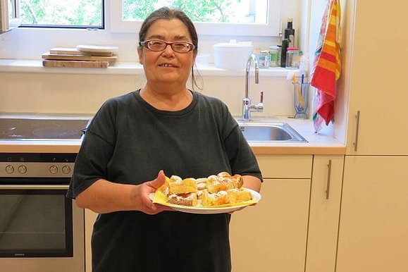 Frau präsentiert ihren fertigen Kuchen