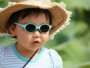 Ein Kleinkind mit Sonnenhut und Sonnenbrille 