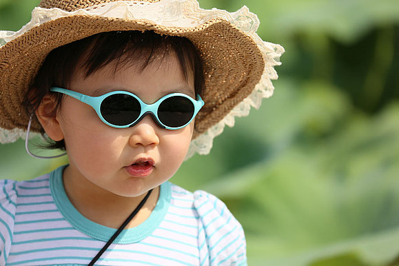 Ein Kleinkind mit Sonnenhut und Sonnenbrille 