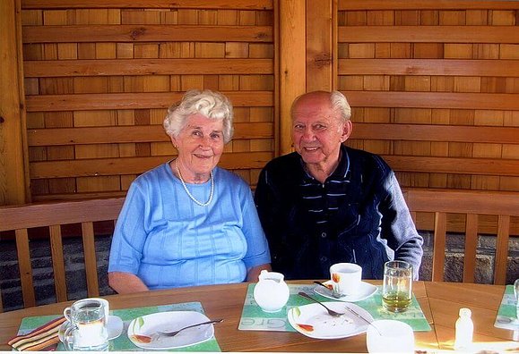 Eine ältere Dame und ein Älterer Herr sitzen bei Tisch