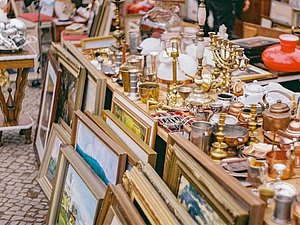 Flohmarktstand mit Gemälden, Kerzenhaltern, Lampen und allerlei Krimskrams