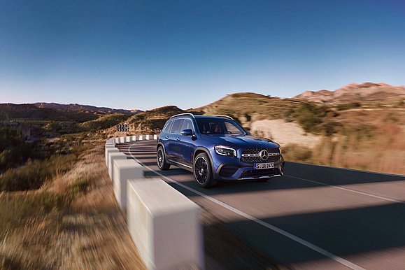 Dunkelblauer Mercedes-Benz GLB fährt auf einer Landstraße.