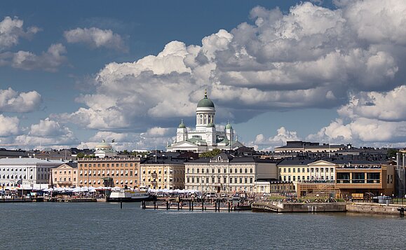 Ein atemberaubender Blick auf die lebendige Stadtlandschaft von Helsinki mit der ikonischen Helsinki Kathedrale unter einem dramatischen Himmel.