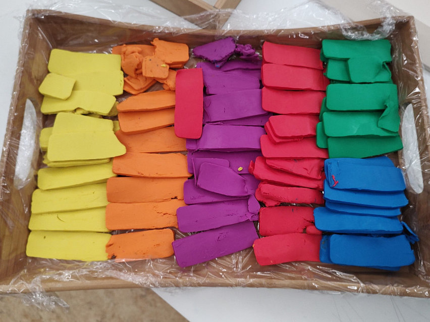 Plastilin-Blöcke in verschiedensten Farben liegen in einem Karton.